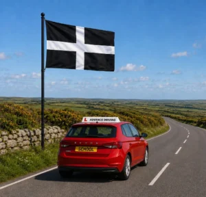 Red Advance Driving School learner car driving along cornish country road beneath St Piran’s Flag